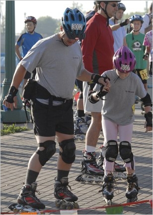 Father skater helps daughter skater